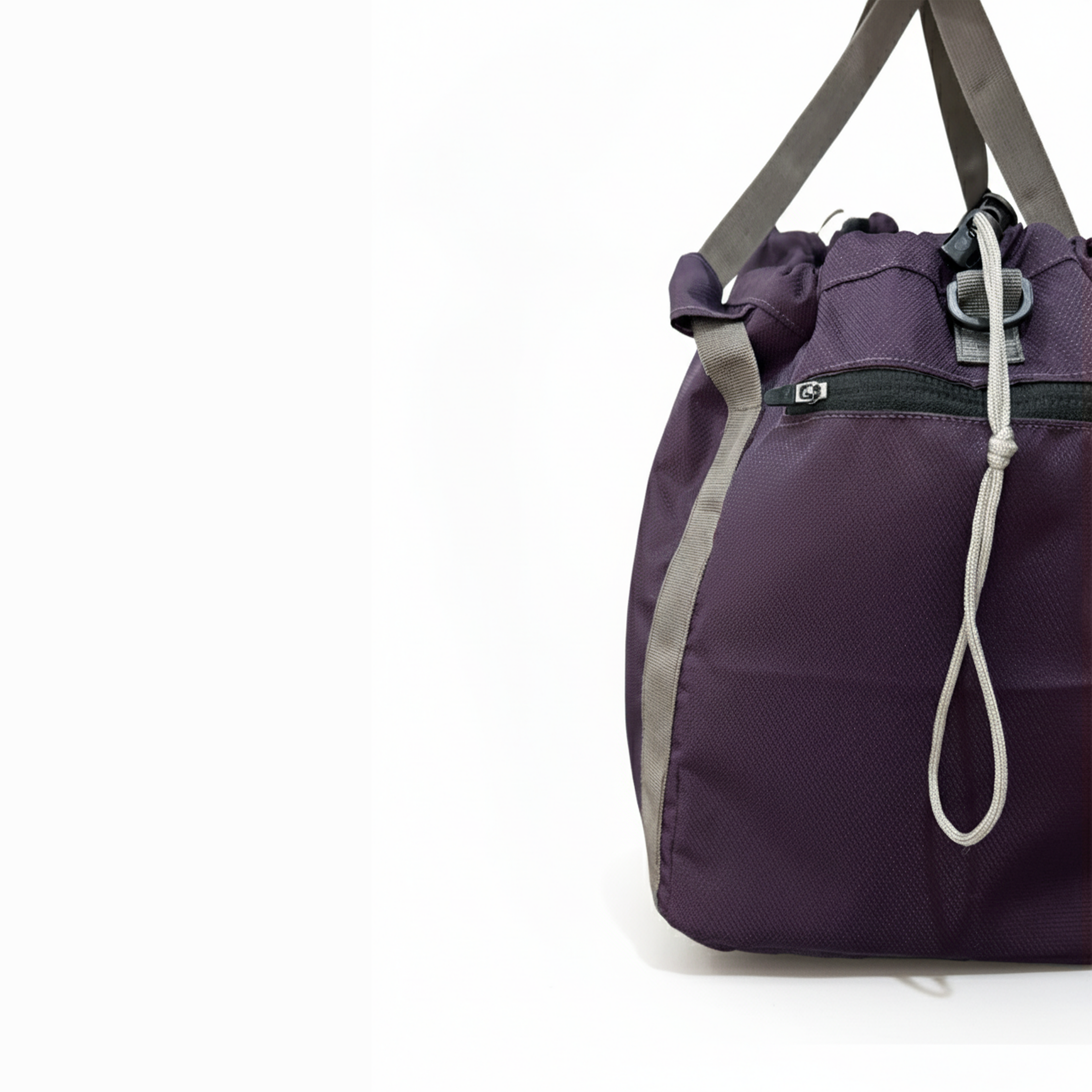 Detail shot of a purple nylon gym tote, highlighting the side zippered pocket and strap attachment.