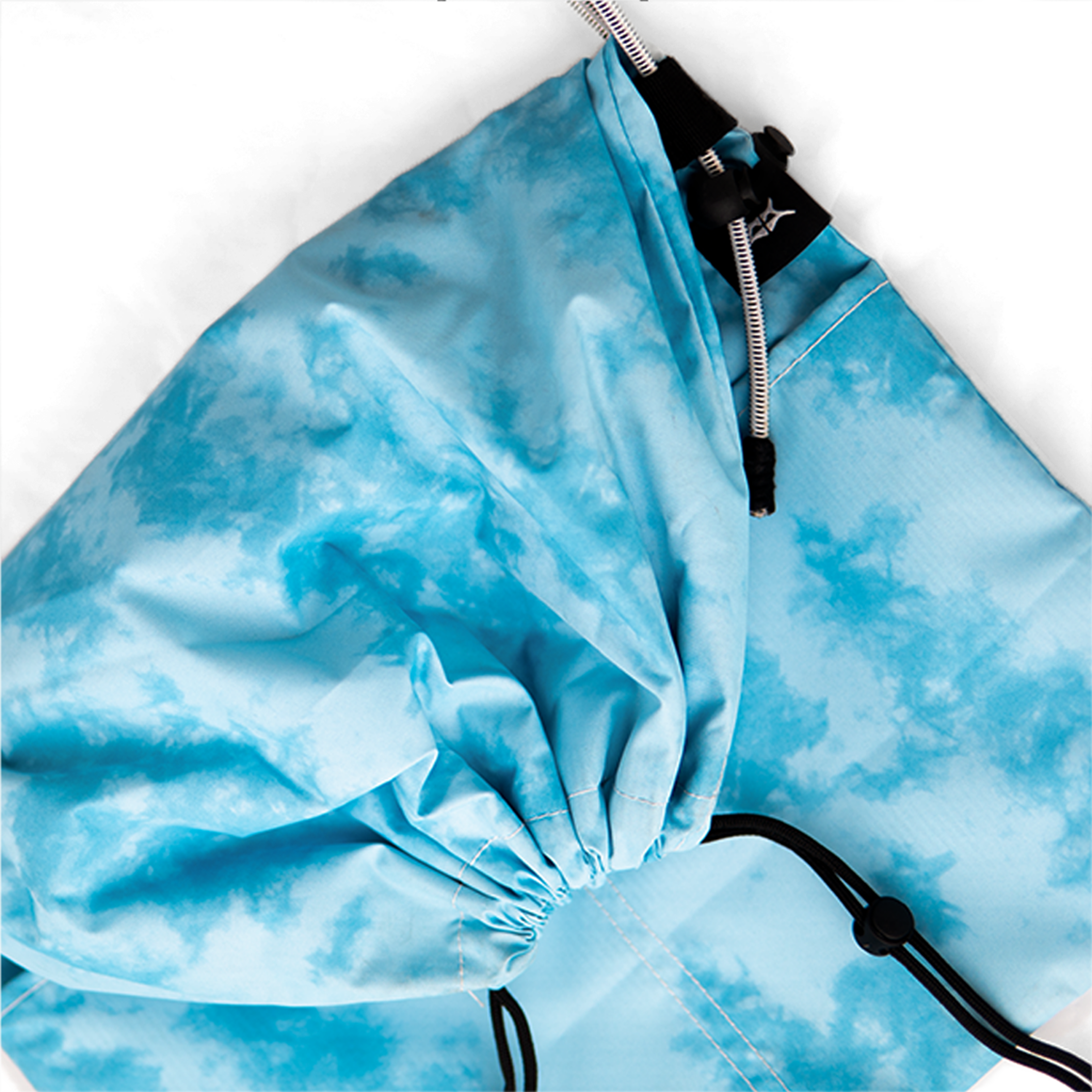 top-down view of a tie-dye blue water-resistant utility bag with drawstring closure.