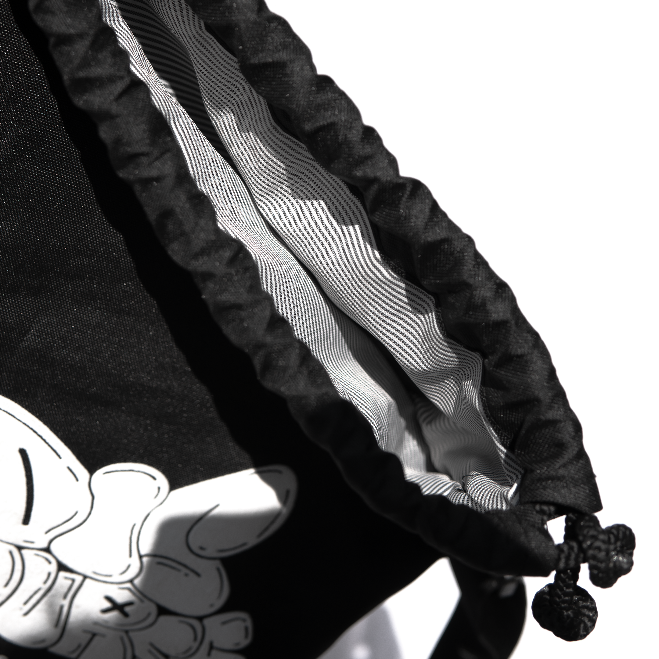 Close-up of a black drawstring bag's opening, showing the striped interior lining.