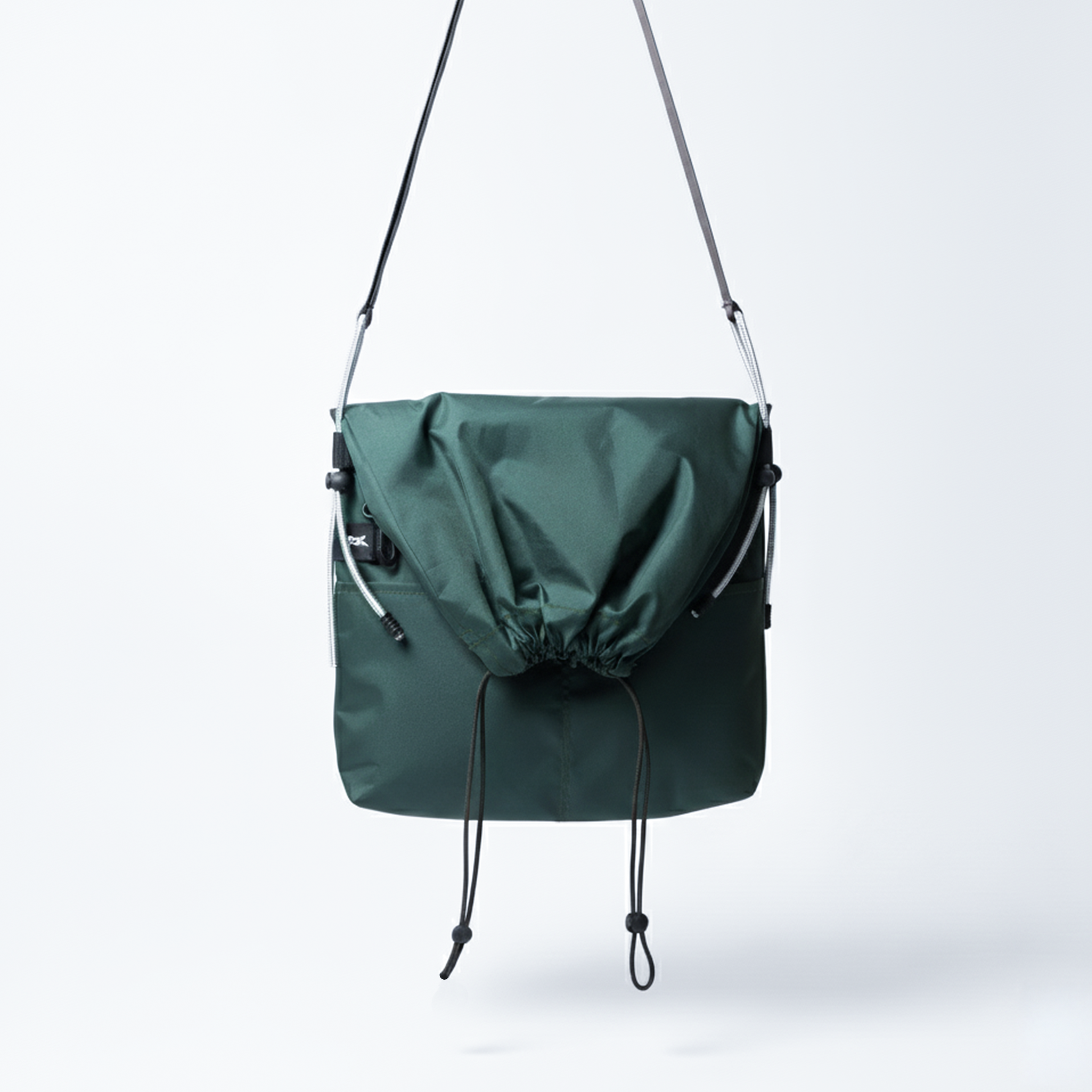 Water-resistant forest green crossbody bag, a small everyday utility sling with a drawstring.
