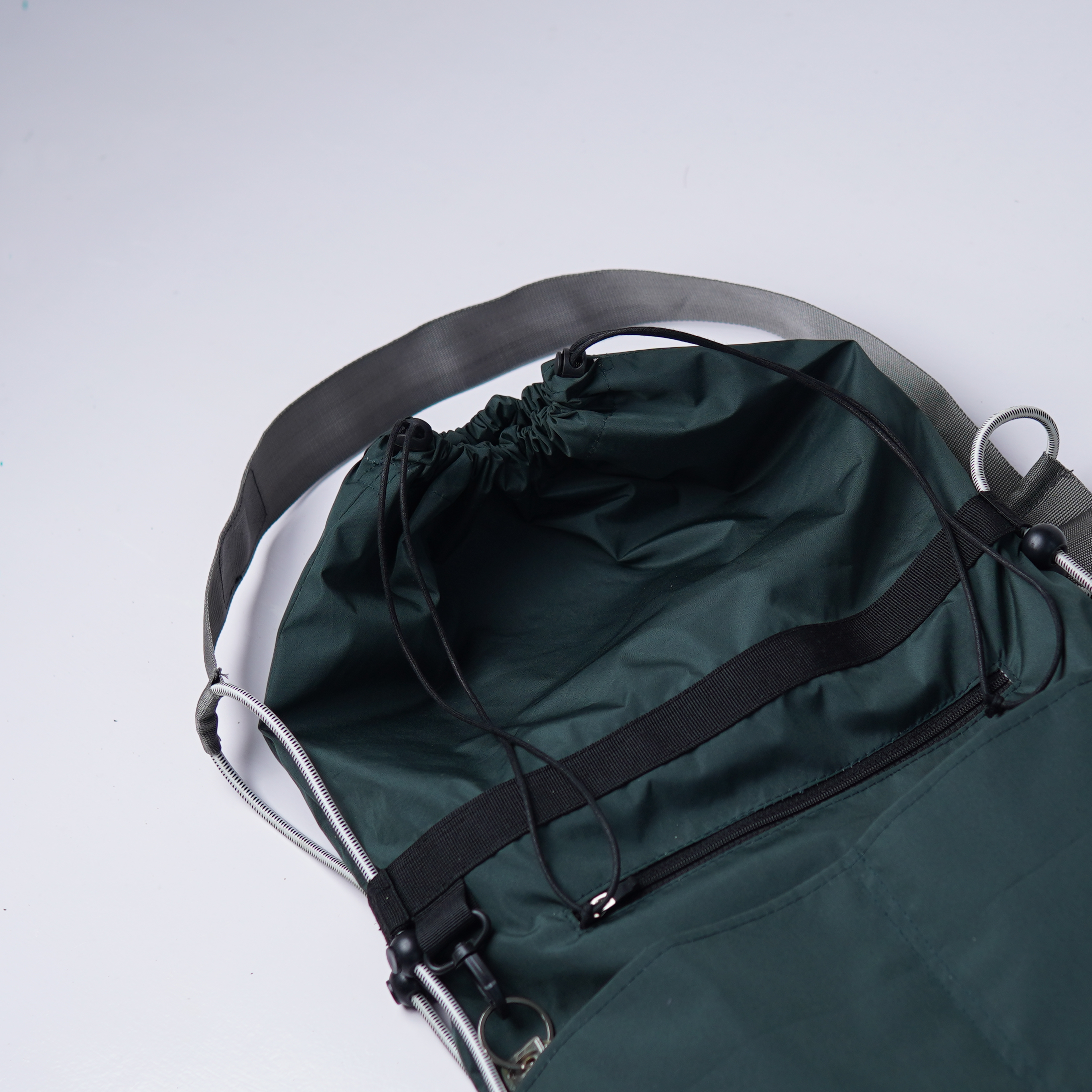 Interior view of a water-resistant forest green utility bag with drawstring closure.